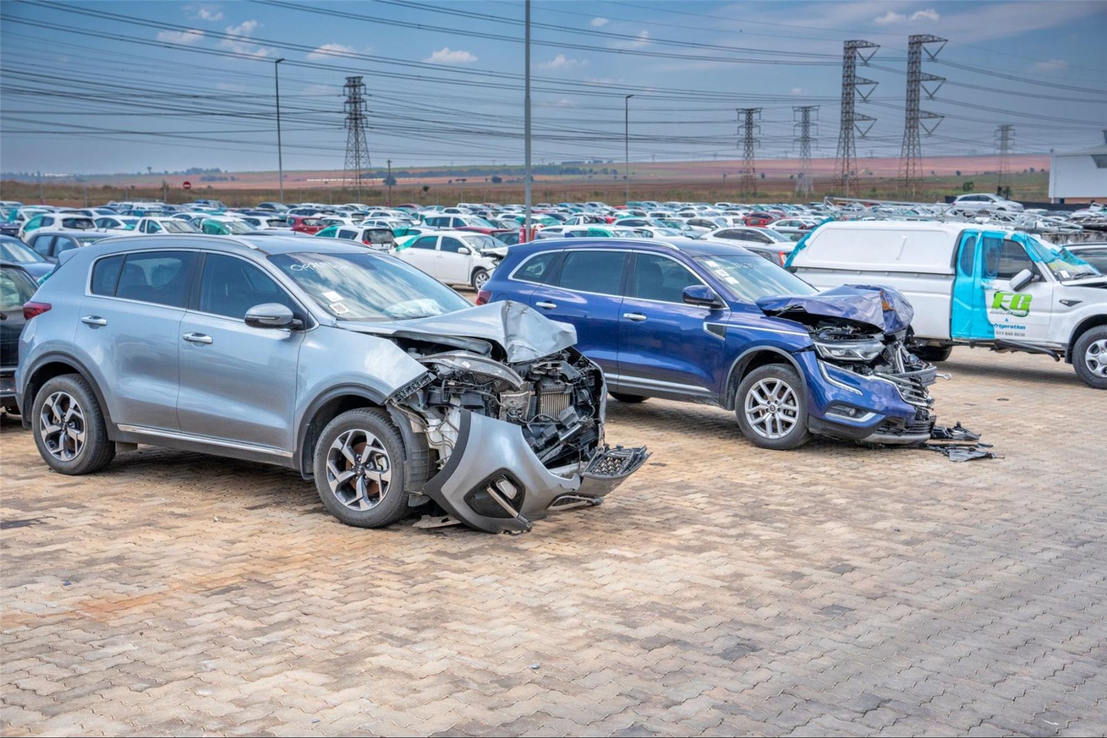 Front-end accident damage on two SUVs at a vehicle salvage yard