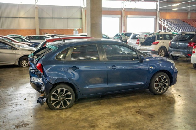 Blue damaged hatchback sold to Sell Your Damaged Car before losing more value in a home garage.